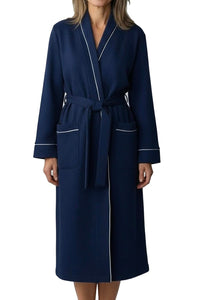 Woman wearing a navy blue robe with white trim on a white background