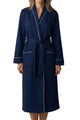 Woman wearing a navy blue robe with white trim on a white background